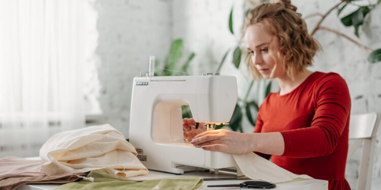 woman sewing while sitting on chair