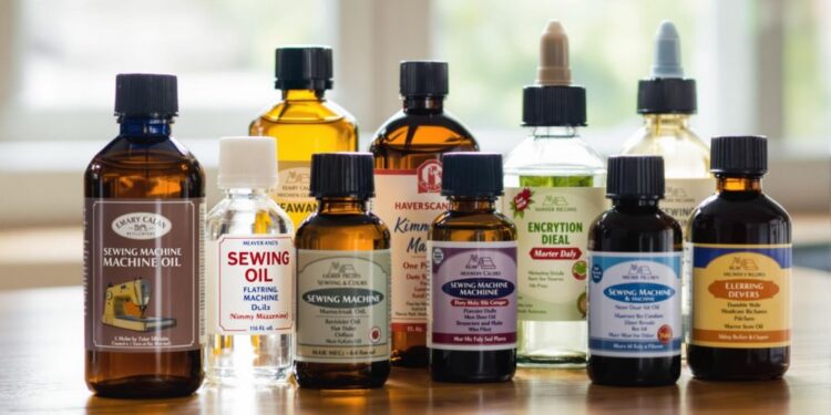 Bottles of sewing machine oil on a wooden surface.