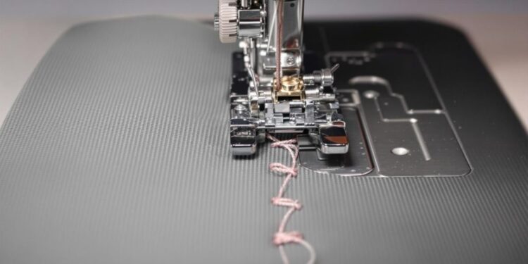 Close-up of sewing machine with skipped stitches on fabric.