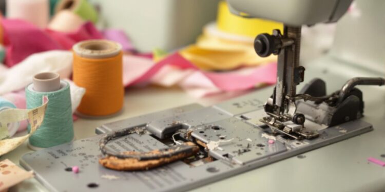 Vintage sewing machine with worn parts and colorful threads.